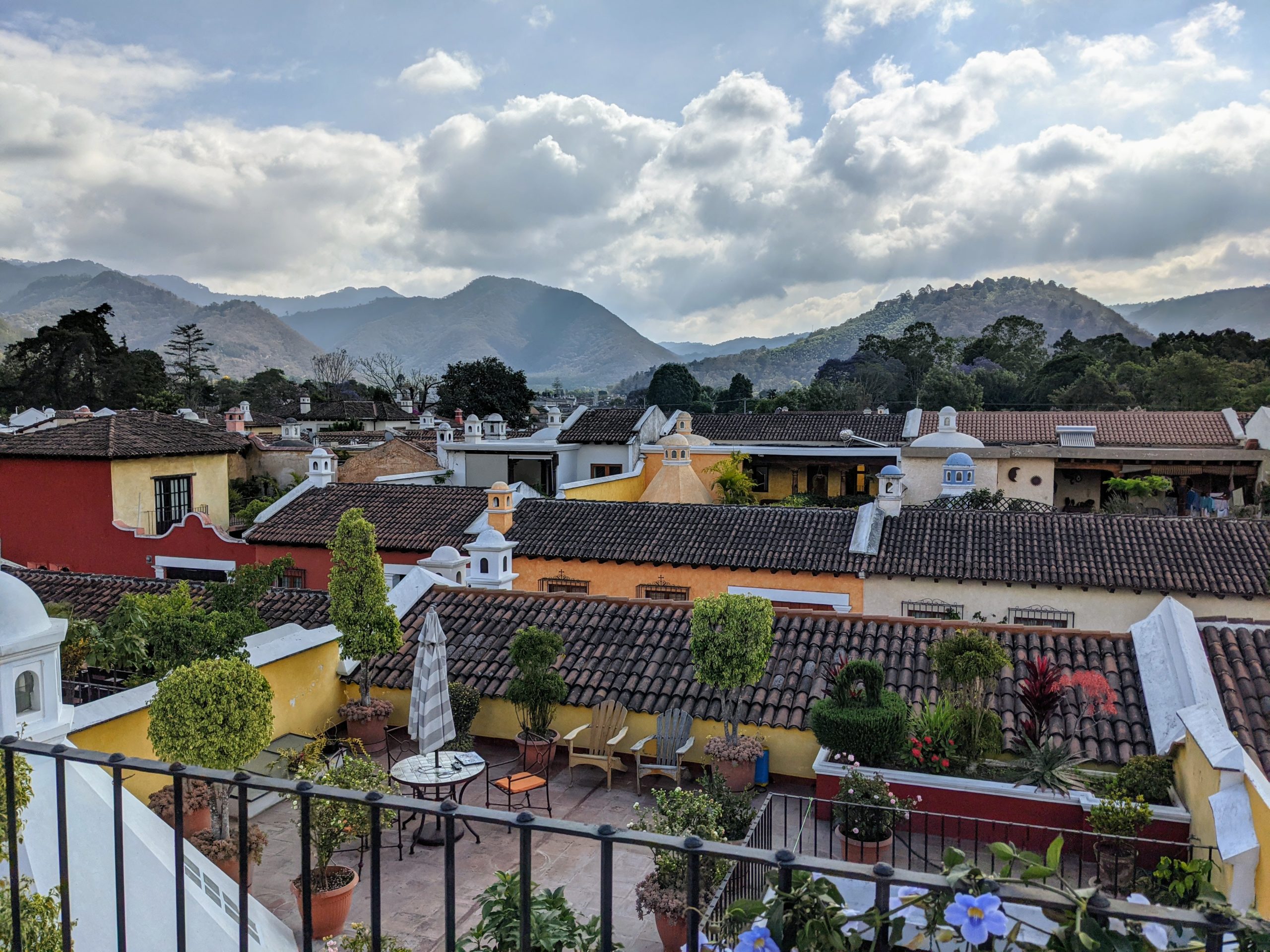 looking out across the tile rooftops of several colorful neighborhoods in Antigua, Guatemala