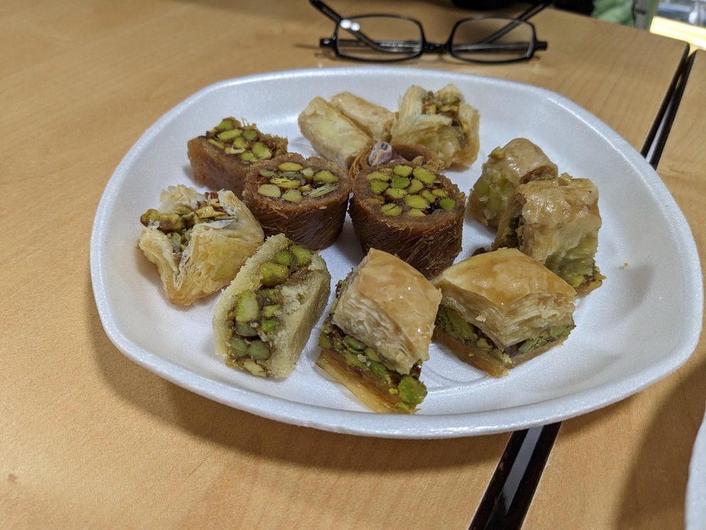 a white plate with many slices of baklava filled with pistachios