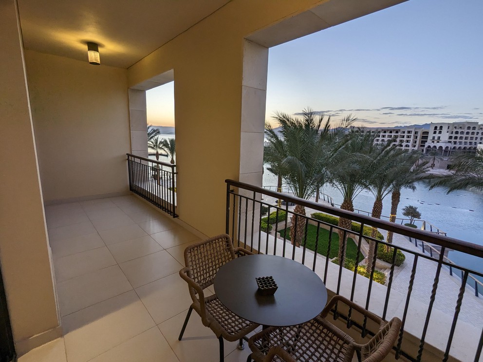 a table and chairs give perspective to this large balcony overlooking an inlet on the gulf of Aqaba