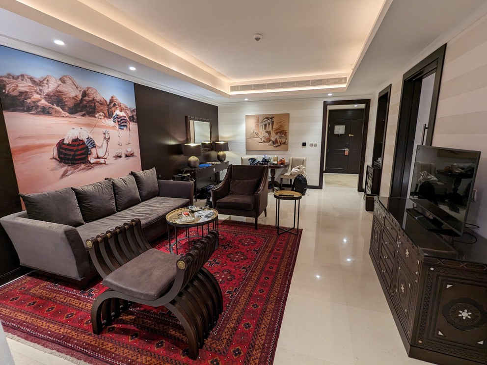 a long marble-floored living room with a painting on the wall almost as wide as the eight-foot-wide couch