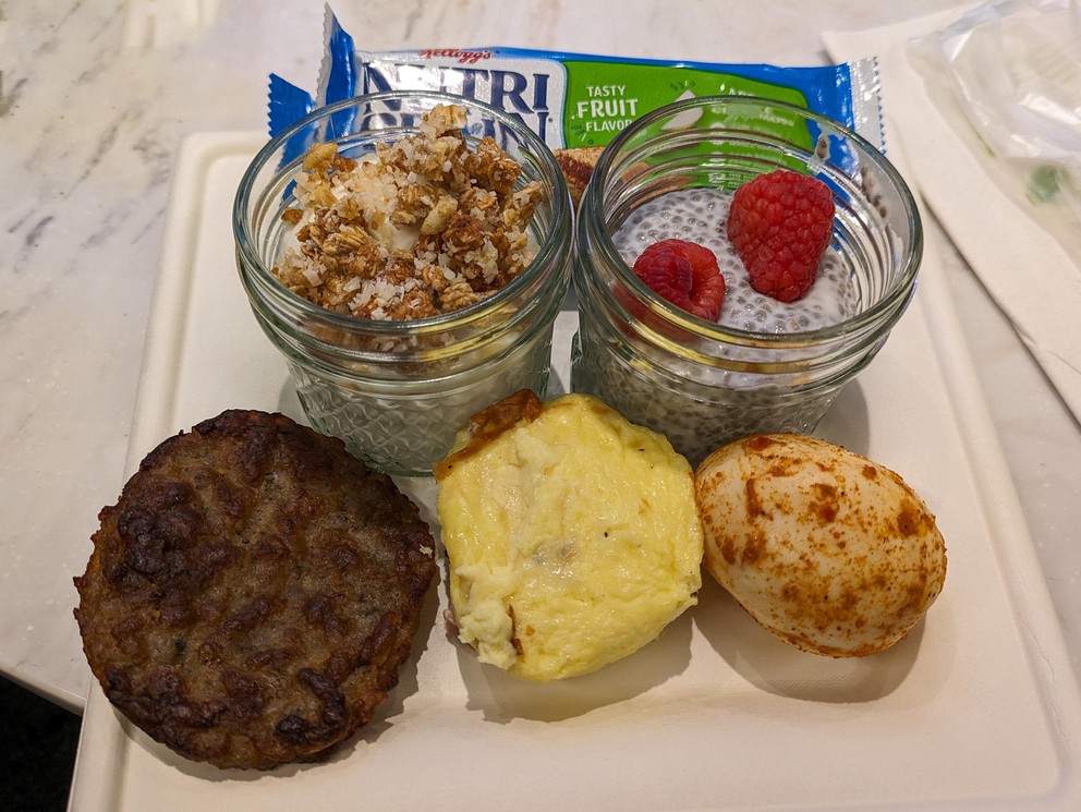 a breakfast plate with sausage, egg, and pudding