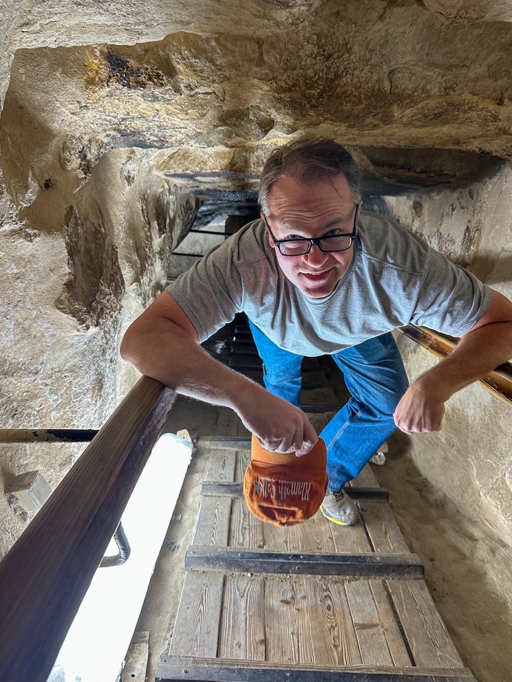 a man climbs up a wooden ramp inside a narrow stone shaft inside the Pyramid of Khufu