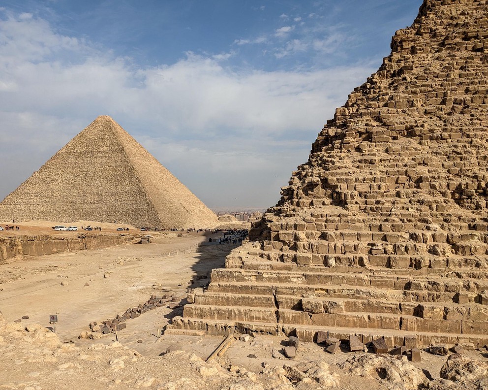a view of traffic going between two pyramids in the Giza Necropolis