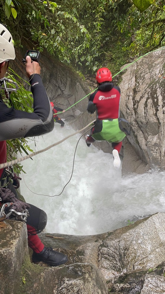 an adventurer jumps from a cliff into a waterfall