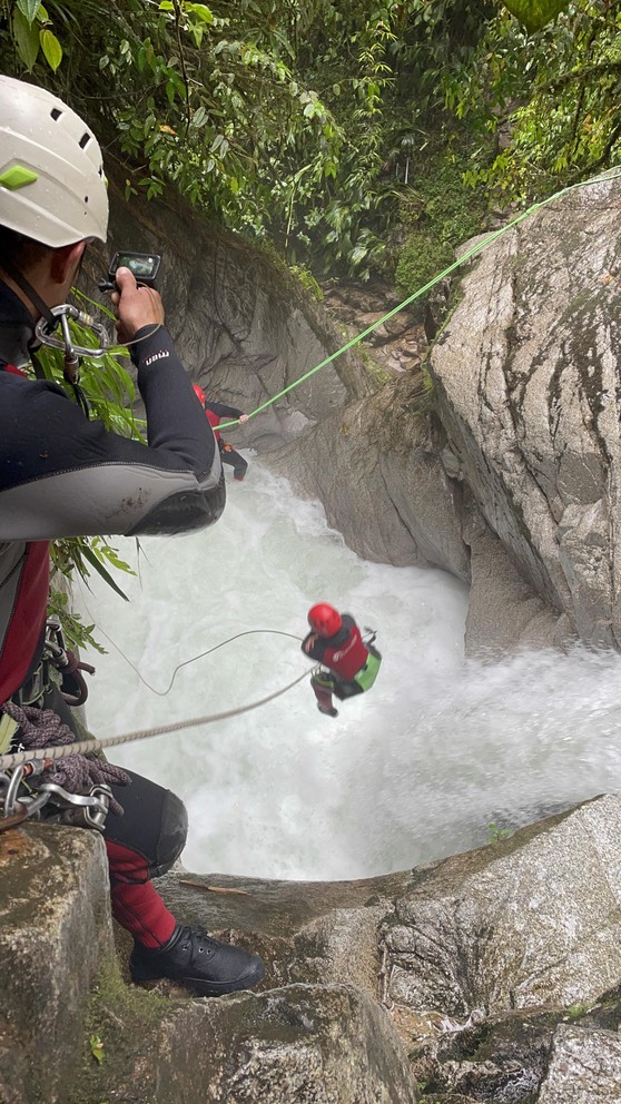 an adventurer jumps into the flow of a waterfall