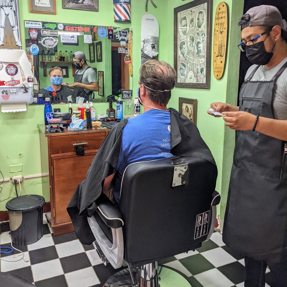 a barber prepares a patron for his haircut