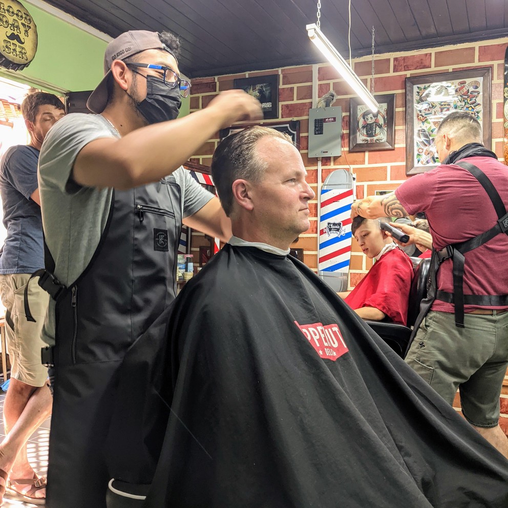 two patrons receiving haircuts at the Classic Barber Shop in Antigua, Guatemala