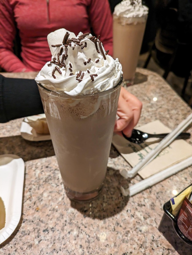 a chocolate milkshake with whipped cream and chocolate sprinkles on top