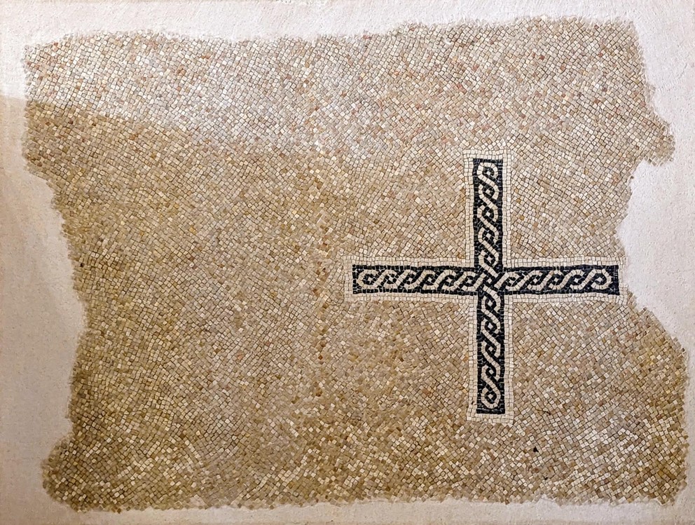 a mosaic tile floor showing a black cross with white braids