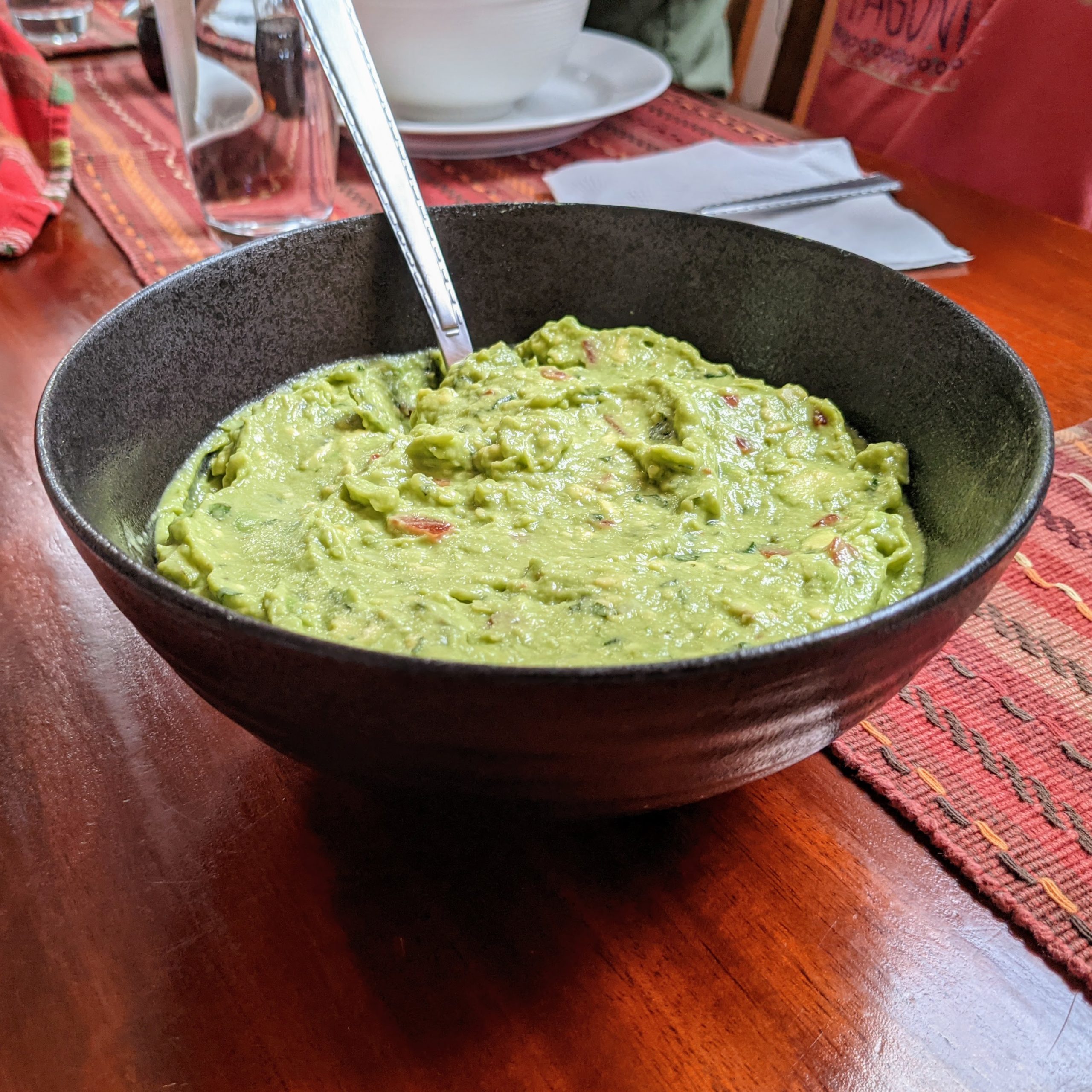 a large bowl filled with guacamole sits on a table