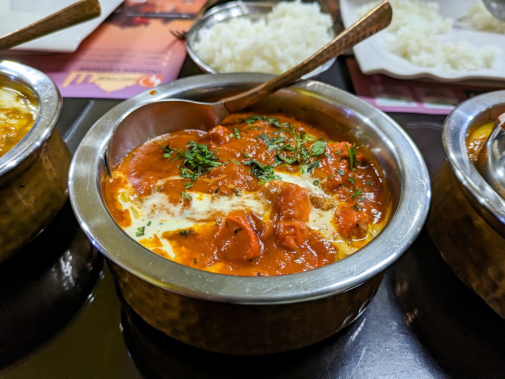a bowl of chicken tikka masala on a table in a restaurant