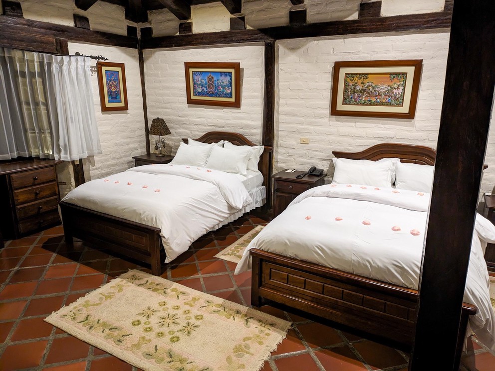 a hotel room with two queen-size beds with flower petals laid across each