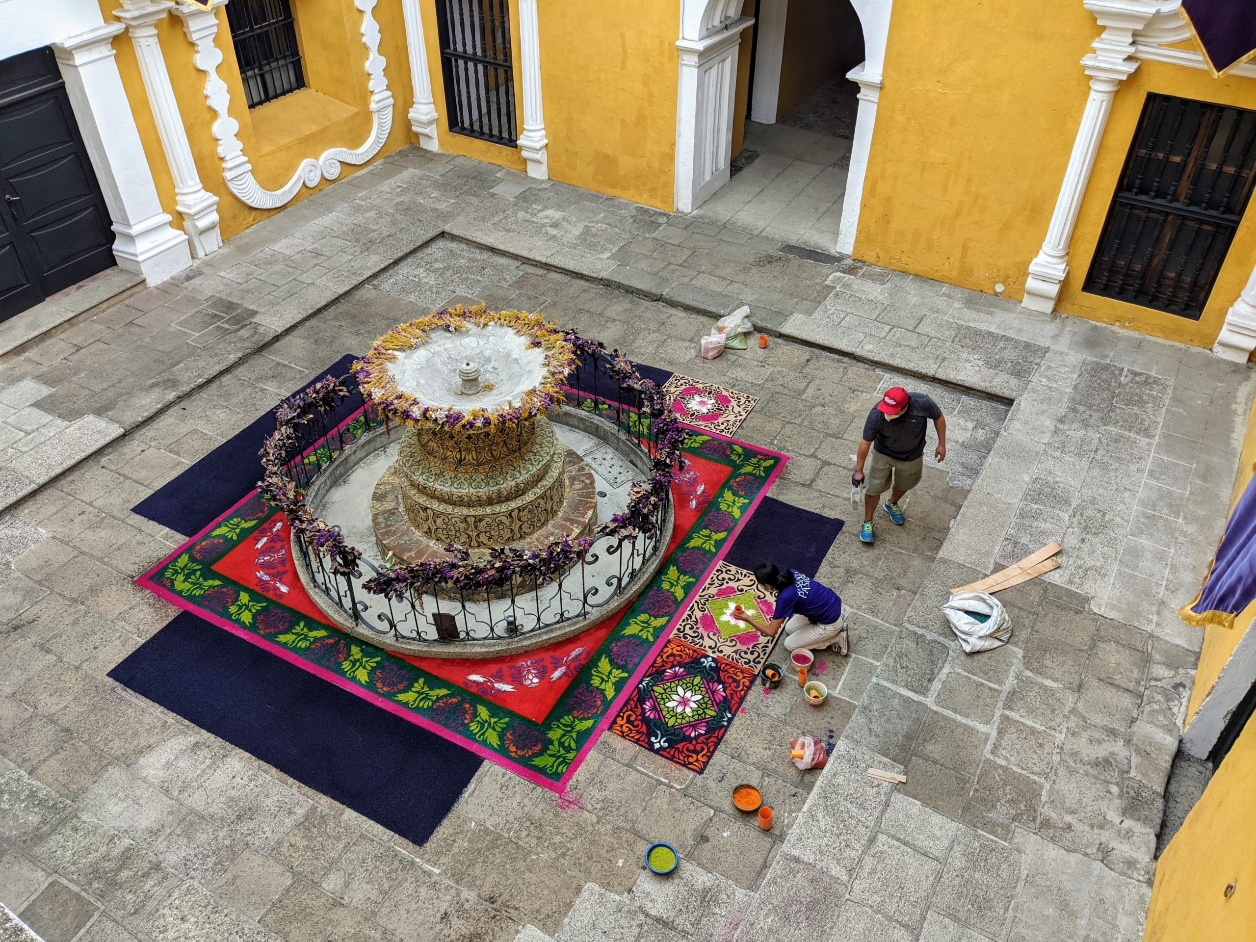 artists build carpets out of colored sawdust around a fountain in Antigua, Guatemala for Holy Week