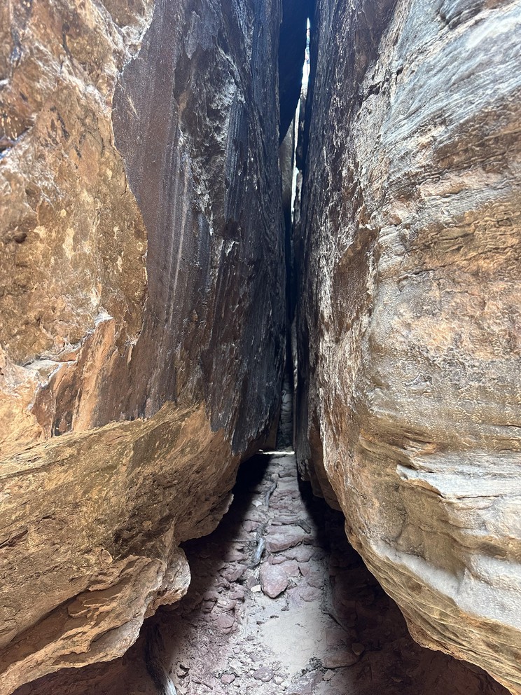 a crack in a narrow sandstone rises hundreds of feet