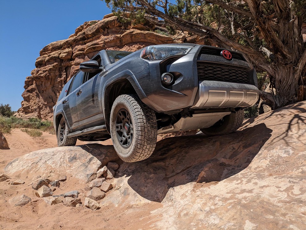 a Toyota 4Runner with one front wheel suspended in the air as it overcomes an obstacle