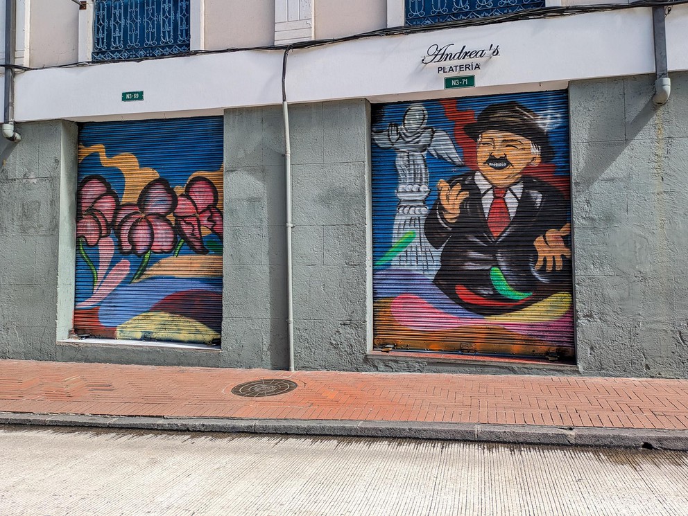 a painting of a smiling man on the closed garage door to a vendor