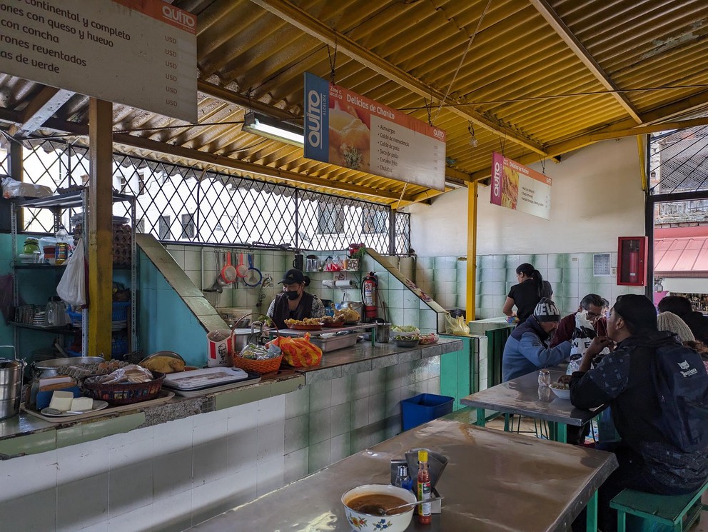 Ecuadorians sit at tables inside a covered cafe