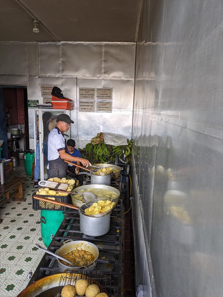 a row of pots boiling empanadas in oil