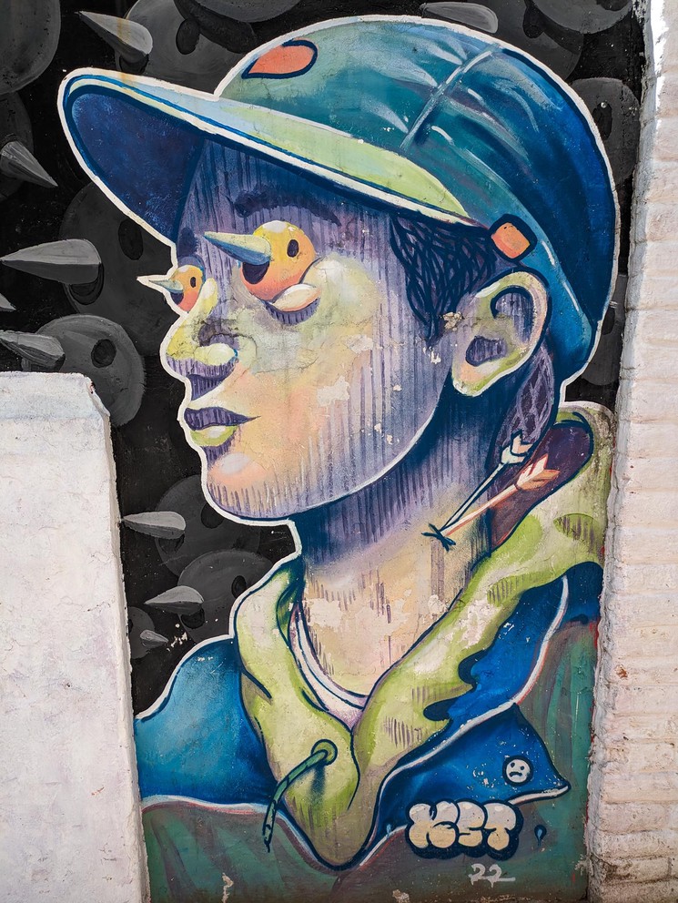 a mural of a man with the head of a bird in place of each of his eyes