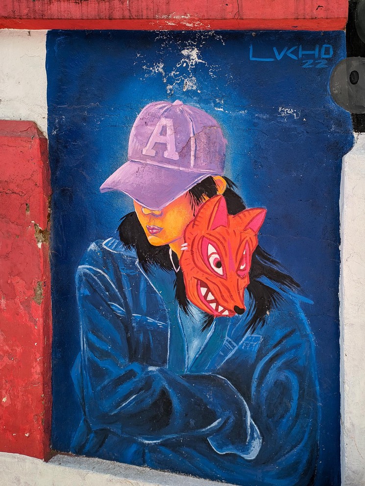 a mural of a woman wearing a jacket with an angry dog poking its head out of the jacket