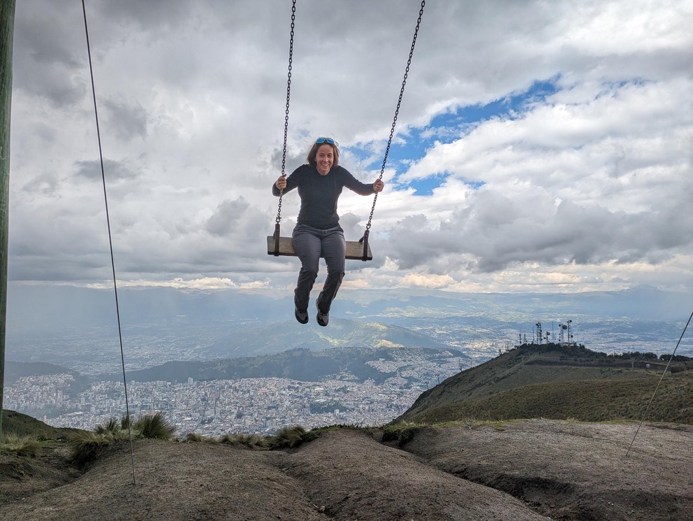 a woman laughs as she enjoys swinging high above Quito, Ecuador