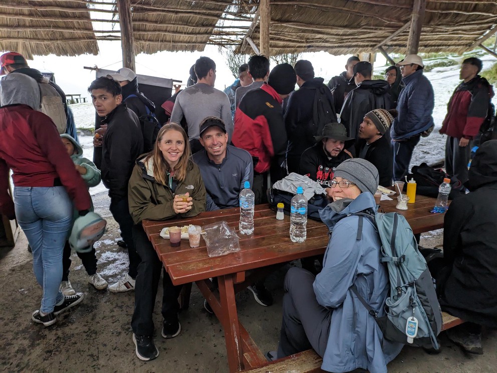 a group of people packs together in a small restaurant to wait out a storm