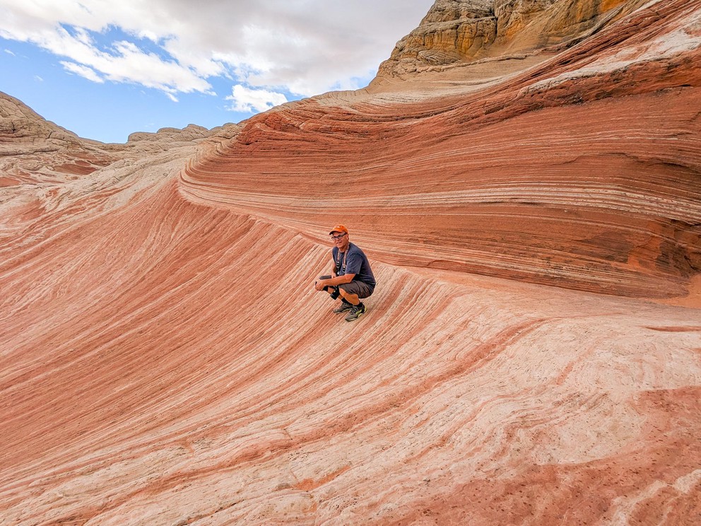 layers of red and white sandstone have been pulled in two very different directions here making an interesting ridge where a man sits