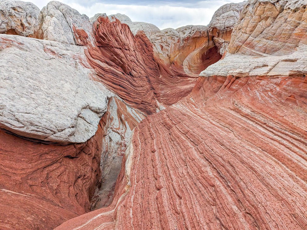 lines of red and white sandstone lead your eyes into a spiral that some call a wormhole